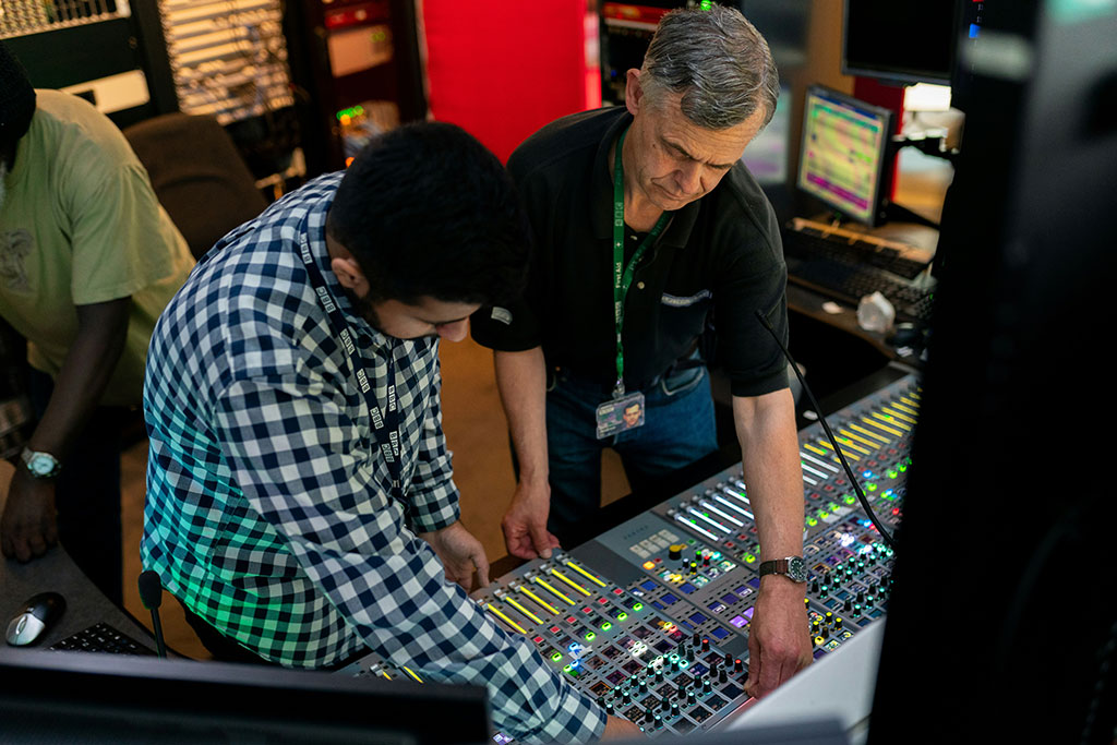 two men working an audio mixer